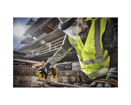 Ouvrier du bâtiment coupant de l'acier avec une meuleuse DeWalt sur un chantier