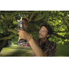 Un homme coupe une branche avec un sécateur à batterie Worx Nitro.