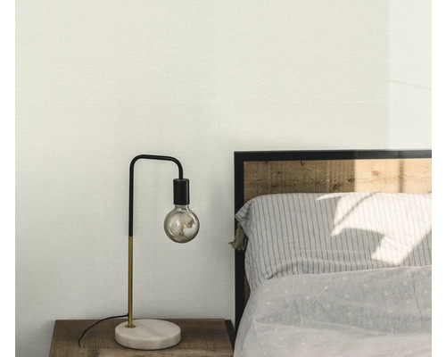Schlafzimmerszene mit Nachttischlampe auf Holztisch neben Bett