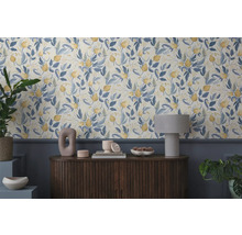 Vue d'une pièce avec du papier peint à motifs floraux et une commode en bois avec des objets décoratifs