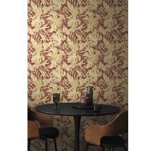 Gros plan d'un mur avec du papier peint à motifs de feuilles et une table ronde avec des chaises