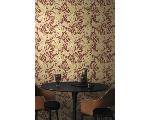 Gros plan d'un mur avec du papier peint à motifs de feuilles et une table ronde avec des chaises