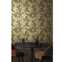 Une pièce avec un papier peint à motif de feuilles, une table à manger et des chaises.