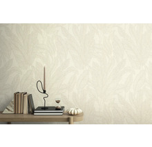 Mur avec papier peint à motif de feuilles, décoré de livres, d'une bougie et d'un sablier sur une table.