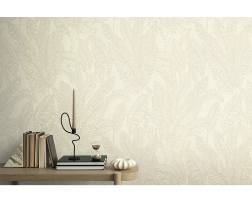 Mur avec papier peint à motif de feuilles, décoré de livres, d'une bougie et d'un sablier sur une table.