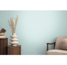 Wohnraum mit Sessel, Holztisch und dekorativer Vase