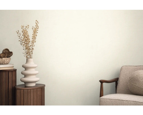 Ambiance de salon avec table d'appoint, vase avec fleurs séchées et fauteuil