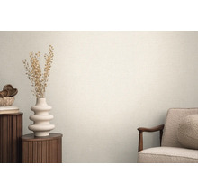 Pièce lumineuse avec des papiers peints structurés, décorée d'un vase et d'un fauteuil pour une ambiance chaleureuse.