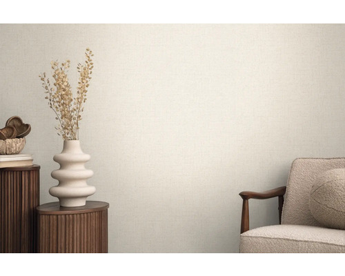 Pièce lumineuse avec des papiers peints structurés, décorée d'un vase et d'un fauteuil pour une ambiance chaleureuse.