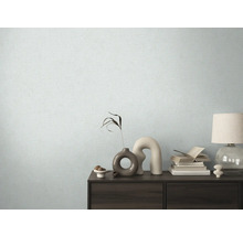 Espace de vie avec papier peint à motifs et commode avec des éléments décoratifs.