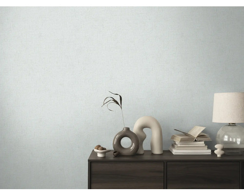 Espace de vie avec papier peint à motifs et commode avec des éléments décoratifs.