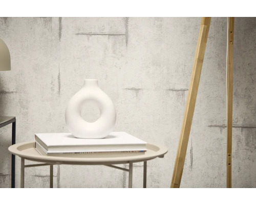 Mur décoratif avec structure en ciment et un élément en bois appuyé contre celui-ci.