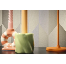 Nahaufnahme einer gemusterten Tapete mit geometrischen Formen im Hintergrund von drei Kerzenständern.