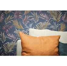 Papier peint décoratif avec motif de feuilles et coussins au premier plan.