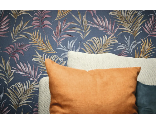 Papier peint décoratif avec motif de feuilles et coussins au premier plan.