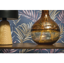 Scène décorative avec une lampe, un vase et un papier peint à motifs.