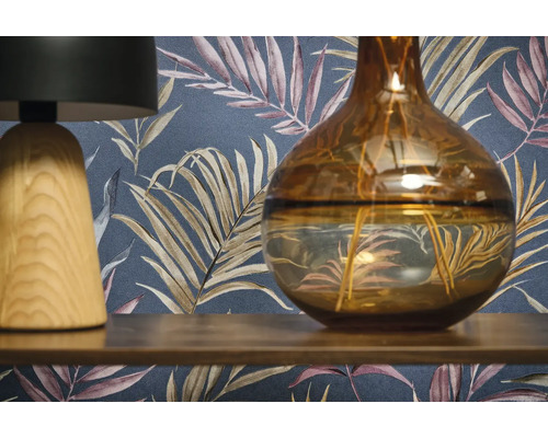 Scène décorative avec une lampe, un vase et un papier peint à motifs.