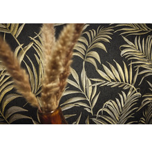 Gros plan d'un papier peint noir avec un motif de feuilles de palmier dorées