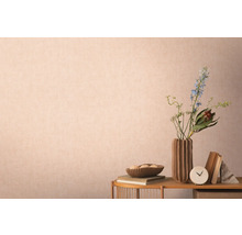 Dekorative Szene mit Vase, Blumen, Büchern und Accessoires auf einem Tisch vor einer Wand