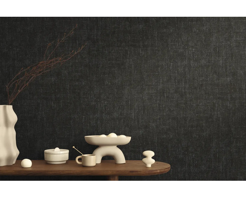 Stilvolle Raumgestaltung mit dunkler Vliestapete und dekorativen Elementen auf einem Holztisch.