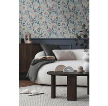 Salon avec papier peint à motifs floraux, canapé, table et décorations pour une ambiance chaleureuse.