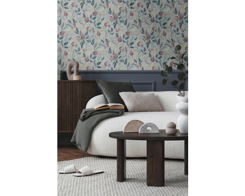 Salon avec papier peint à motifs floraux, canapé, table et décorations pour une ambiance chaleureuse.