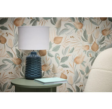 Scène avec papier peint à motif floral, lampe de table et livre sur table d'appoint