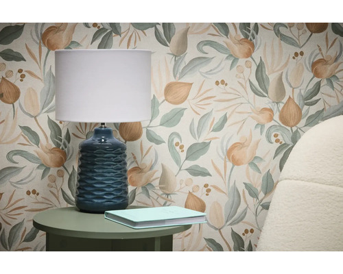 Scène avec papier peint à motif floral, lampe de table et livre sur table d'appoint