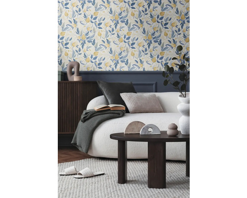 Salon avec papier peint floral, canapé, table basse et accessoires décoratifs pour une ambiance chaleureuse.