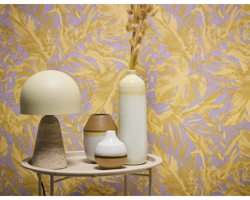 Nature morte décorative avec lampe de table et vases devant un papier peint à motifs végétaux.