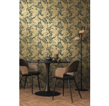 Salle à manger avec papier peint à feuilles tropicales, table à manger et chaises.