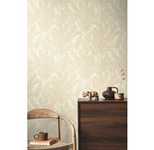 Une pièce avec un papier peint à motifs de feuilles, une chaise en bois et une armoire en bois foncé.