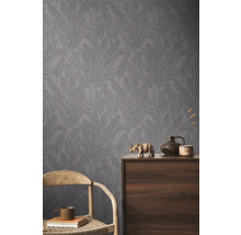 Zimmeransicht mit gemusterter Tapete und dekorativen Elementen auf einem Holzschrank.