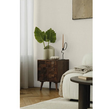 Wohnzimmerszene mit Holzkommode, Pflanze und Kerzenständer