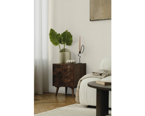 Wohnzimmerszene mit Holzkommode, Pflanze und Kerzenständer