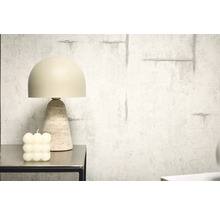 Lampe de table décorative avec pied en travertin à côté d'une bougie à bulles sur une table