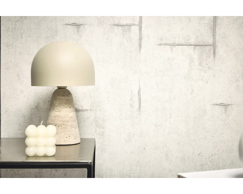 Lampe de table décorative avec pied en travertin à côté d'une bougie à bulles sur une table