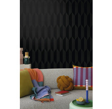Salon avec papier peint noir à motif géométrique et canapé