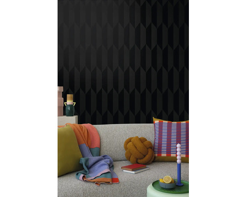 Salon avec papier peint noir à motif géométrique et canapé