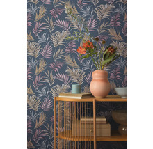 Pièce avec un mur avec un papier peint à motif de feuilles tropicales et une étagère avec des objets de décoration.
