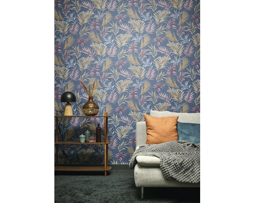 Salon avec un revêtement mural à motif de feuilles de palmier, une étagère et un canapé.