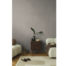 Wohnzimmer mit gemusterter Tapete, Teppich, Sofa und Beistelltisch.