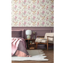 Chambre à coucher avec papier peint à fleurs, lit, fauteuil et table de chevet