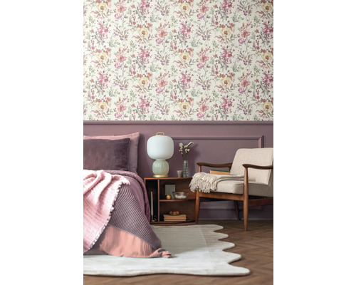 Chambre à coucher avec papier peint à fleurs, lit, fauteuil et table de chevet