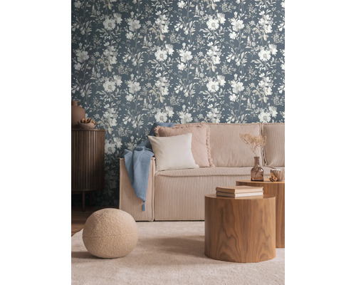 Salon avec papier peint fleuri, canapé et tables en bois