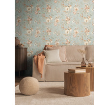 Salon avec papier peint à fleurs, canapé côtelé et tables en bois