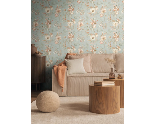 Salon avec papier peint à fleurs, canapé côtelé et tables en bois