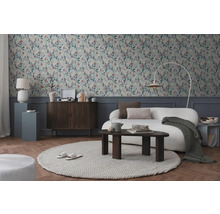 Salon avec papier peint à motifs, canapé, tapis et éléments en bois pour une ambiance chaleureuse