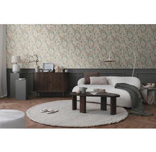 Salon avec papier peint floral, canapé, tapis et meubles en bois pour une ambiance chaleureuse.