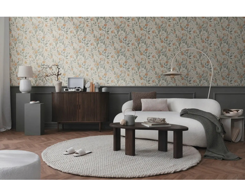 Salon avec papier peint floral, canapé, tapis et meubles en bois pour une ambiance chaleureuse.